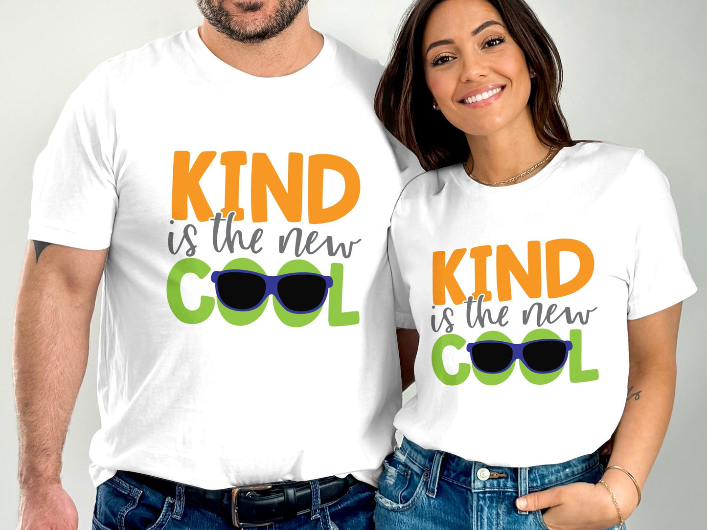 Man and woman wearing white kind is the new cool tee with colorful text and sunglasses graphic