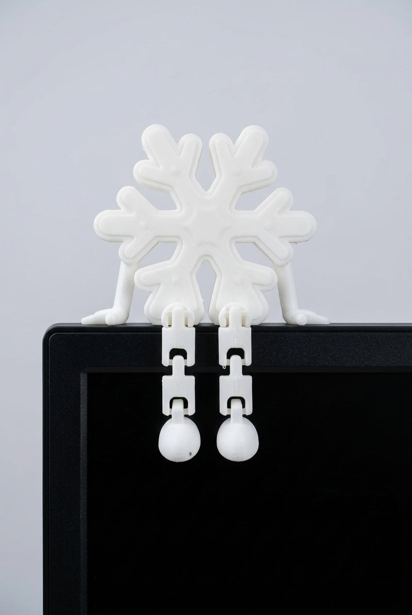 3D printed snowflake buddy with dangling legs sitting on a shelf