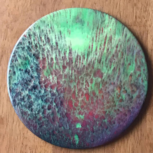Abstract circular art piece featuring vibrant green and purple hues with northern lights glass pour effect